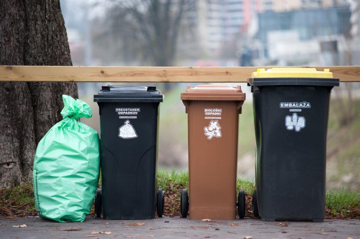 Zabojnik za embalažo, biološke odpadke in mešane komunalne odpadke. Ob zabojnik za mešane komunalne odpadke je prislonjena tipizirana vrečka za mešane komunalne odpadke.